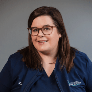 Financial Coordinator, Kristen, smiling in her red glasses and blue Markovitz Orthodontics shirt