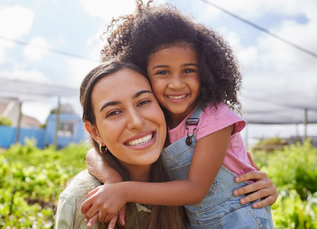 Photogenic mother and daughter beaming in the summer sun