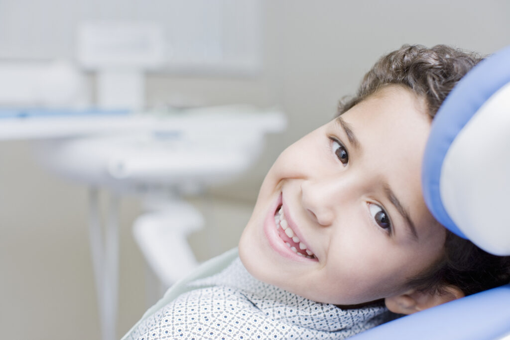 Adorable boy smiling in the orthodontists chair